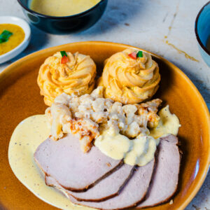 Varkensgebraad met honing-mosterdsaus, gegratineerde bloemkool en Pommes duchesse